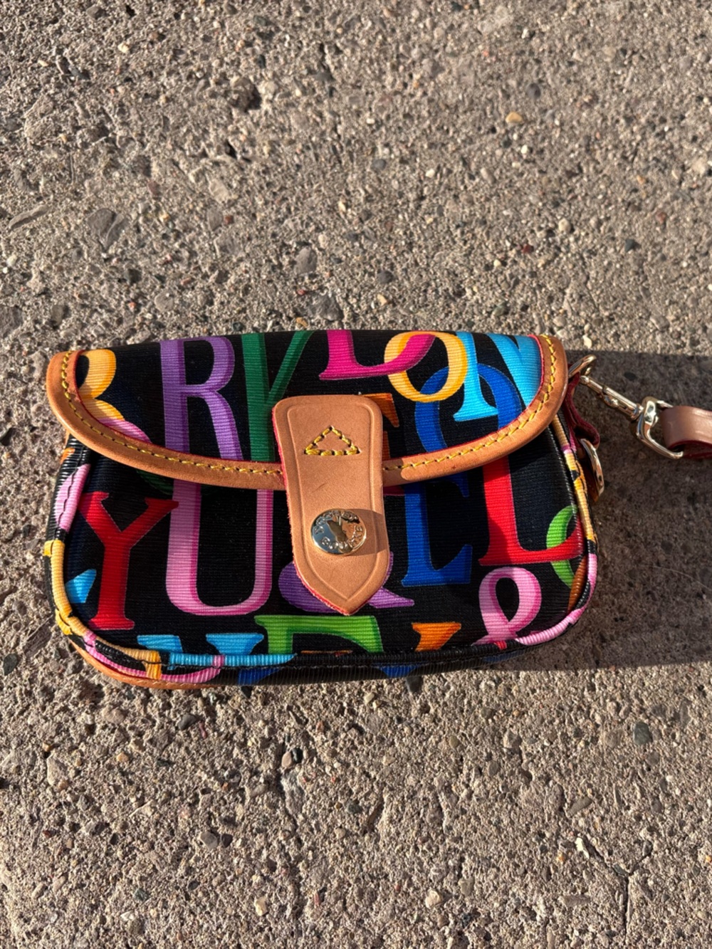 Dooney and Bourke Letter Print wristlet with Tan Trim and Strap